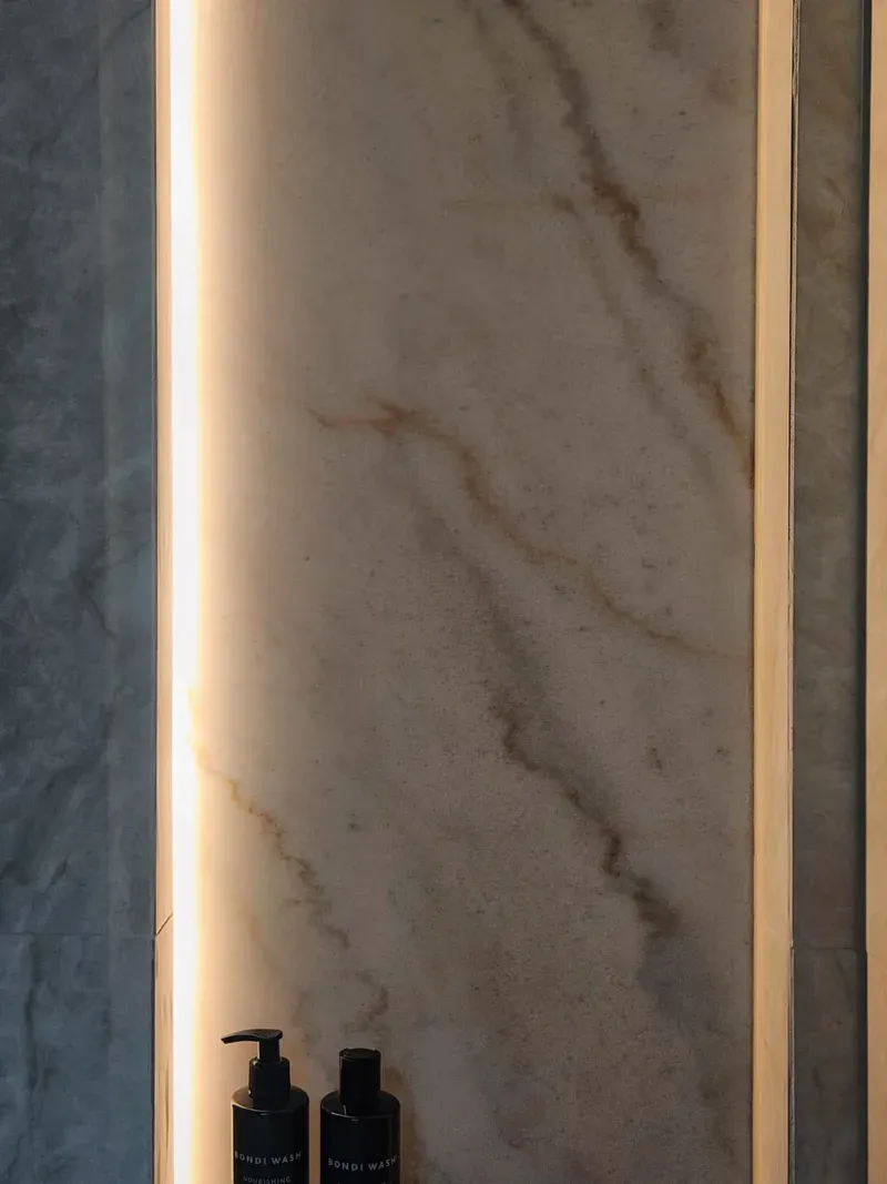 Backlit stone shower niche with LED edge lighting